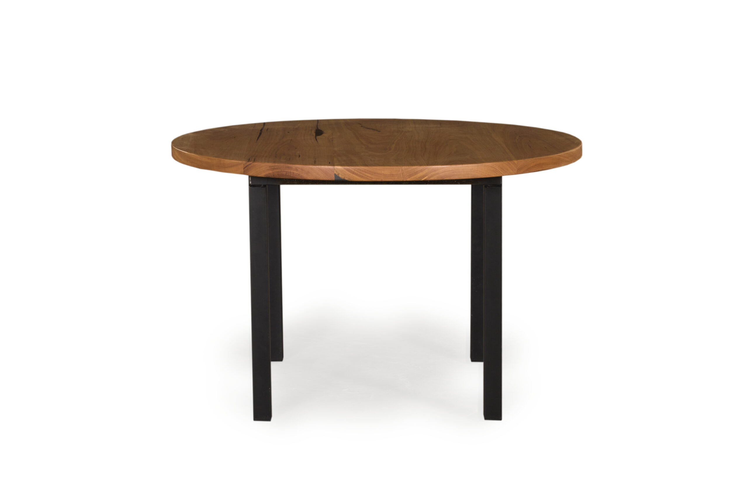Bowden Round Dining Table with Victorian Ash top and black steel 4-leg base.