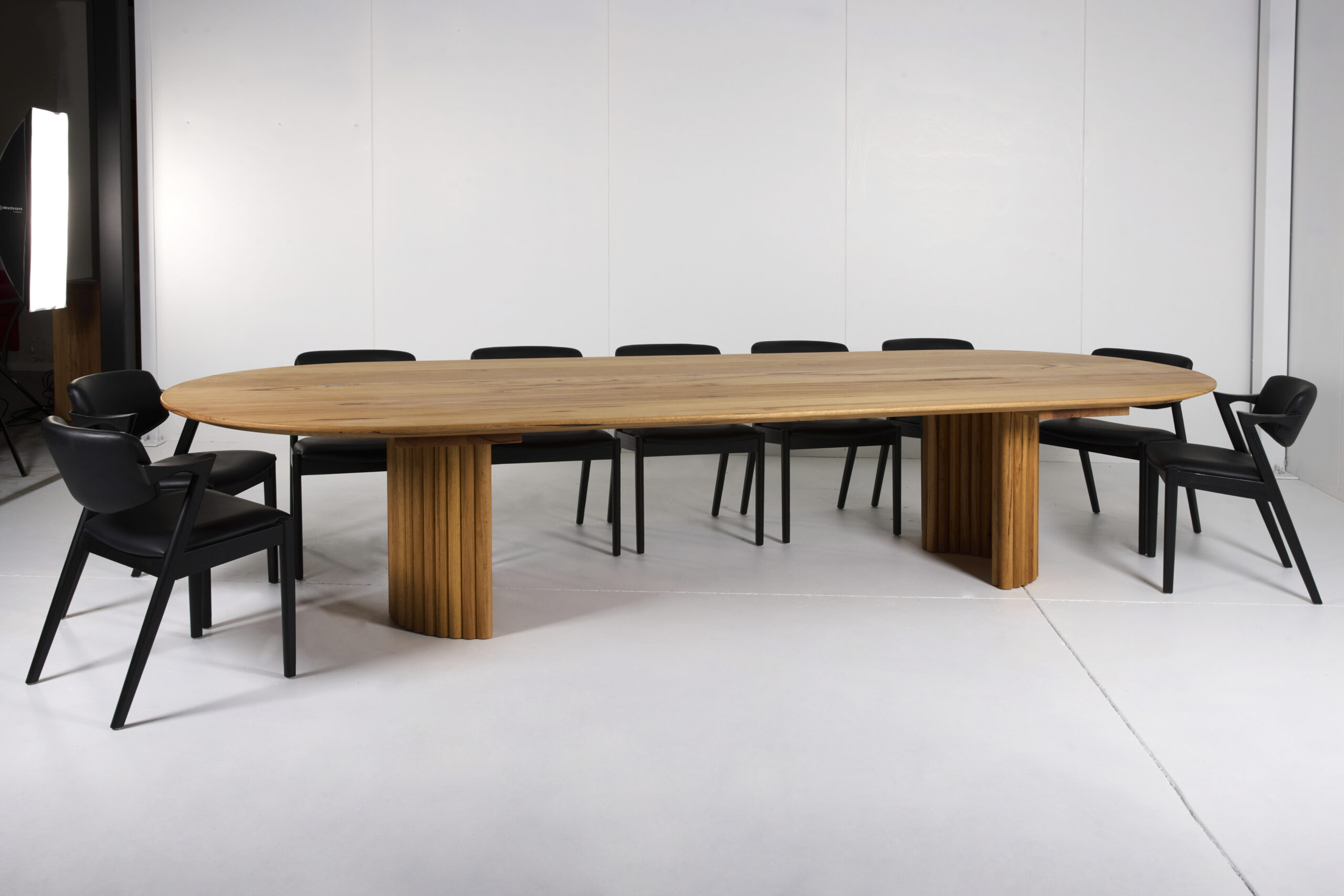 Elegant and modern Nadika Dining Table featuring a solid hardwood frame, high-gloss lacquer finish, and clean lines. The table seats six to eight people and is available in various finishes such as rich walnut and sleek black.